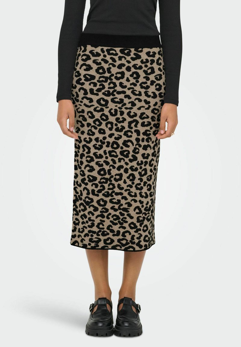 Jupe midi tricotée à imprimé léopard avec une taille élastique noire. Elle présente un fond beige et de grands motifs animaliers noirs.