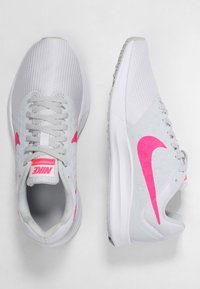 Scarpe da corsa grigio chiaro con accenti rosa, tomaia in rete, colletto imbottito e suola in gomma. Presentano perforazioni rotonde e lacci.