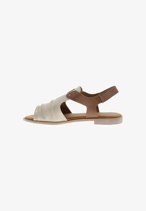 Sandale plate femme avec des brides avant souples beige et une bride de cheville marron ajustable, bout ouvert et talon bas.