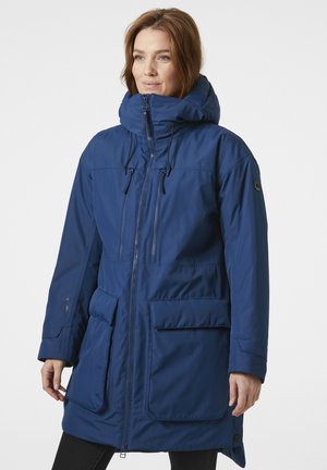 Un largo abrigo parka azul marino con un cuello alto, cierre de cremallera, capucha ajustable y grandes bolsillos frontales. Fabricado con un material suave y resistente a las inclemencias del tiempo.