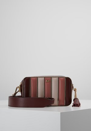 Prostokątna torba na ramię z pionowymi paskami ze skóry w kolorach bordowym, różowym i beżowym, złote logo MK, szeroki pasek i detal z frędzlem na białej powierzchni.