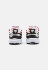 Zapatillas en blanco y negro con acentos rojos. Presentan bordado de Snoopy, parte superior de malla texturizada y cuello acolchado para mayor comodidad.
