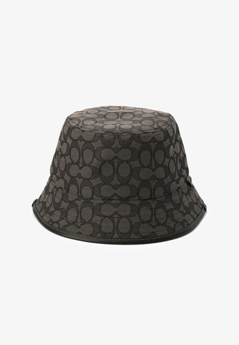 Chapeau de seau noir en tissu texturé avec un motif circulaire répété. Il possède un bord flexible et une bordure cousue pour plus de durabilité.