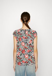 Blusa floral con un fondo oscuro que presenta rosas rojas y margaritas azules, mangas cortas y cierre de cremallera en la parte posterior. Textura de tejido suave.