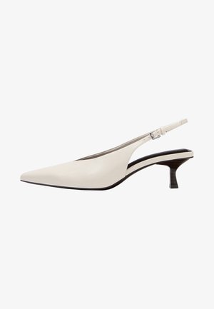 Escarpin slingback en cuir blanc avec talon kitten, bout pointu et sangle réglable à boucle sur fond blanc uni.