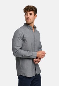 Szara, długorękawowa koszula na guziki z ostrym kołnierzykiem i delikatną fakturą, posiadająca prosty dół oraz guziki z przodu.