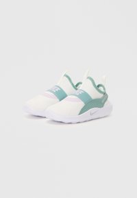 Chaussures Nike à enfiler avec un design blanc et teal, dotées d'un dessus texturé et d'une sangle élastique de soutien au niveau du métatarse.