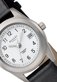 Montre en titane avec un cadran blanc, des index horaires noirs et des aiguilles lumineuses. Présente une fenêtre de date et un bracelet en cuir noir. Résistante à l'eau jusqu'à 5 bars.