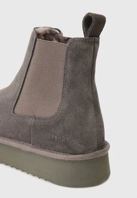 Γκρίζα σουέτ μπότες μέχρι τον αστράγαλο με ελαστική πλευρική επένδυση, υφασμάτινη σόλα με υφή και υφασμάτινο χερούλι πίσω. Ελάχιστη ορατή σήμανση.