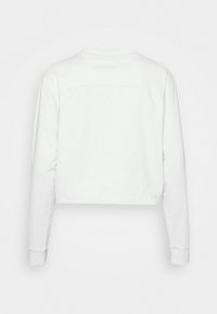 Biała krótka bluza z długimi rękawami, wykonana z miękkiego materiału bawełnianego. Charakteryzuje się minimalistycznym wzornictwem z gładkim tyłem i subtelnymi detalami przeszycia.