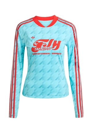 Camisa desportiva de mangas longas em azul claro com detalhes em vermelho e três riscas. Apresenta um texto gráfico em vermelho em destaque e um padrão pied-de-poule.