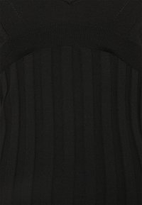 Tissu en maille côtelée noire avec des rayures verticales et un motif tricoté horizontal près du bord supérieur.