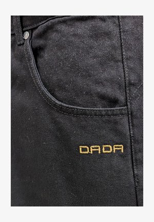 Schwarze Jeans mit einer subtilen Textur, ausgestattet mit einer Fronttasche und dem auf der Seite in Gold gestickten "DADA".