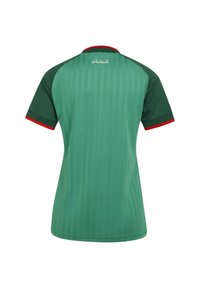 T-shirt de sport vert avec manches vert foncé, bordure de col rouge, poignets de manches rouges, et texte arabe blanc près du haut du dos.