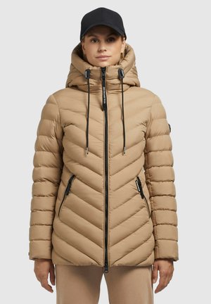 Beige puffer jack met een chevron-quiltpatroon, capuchon, verstelbare trekkoorden, een rits aan de voorkant en zwarte ritszakken. Zachte textuur.