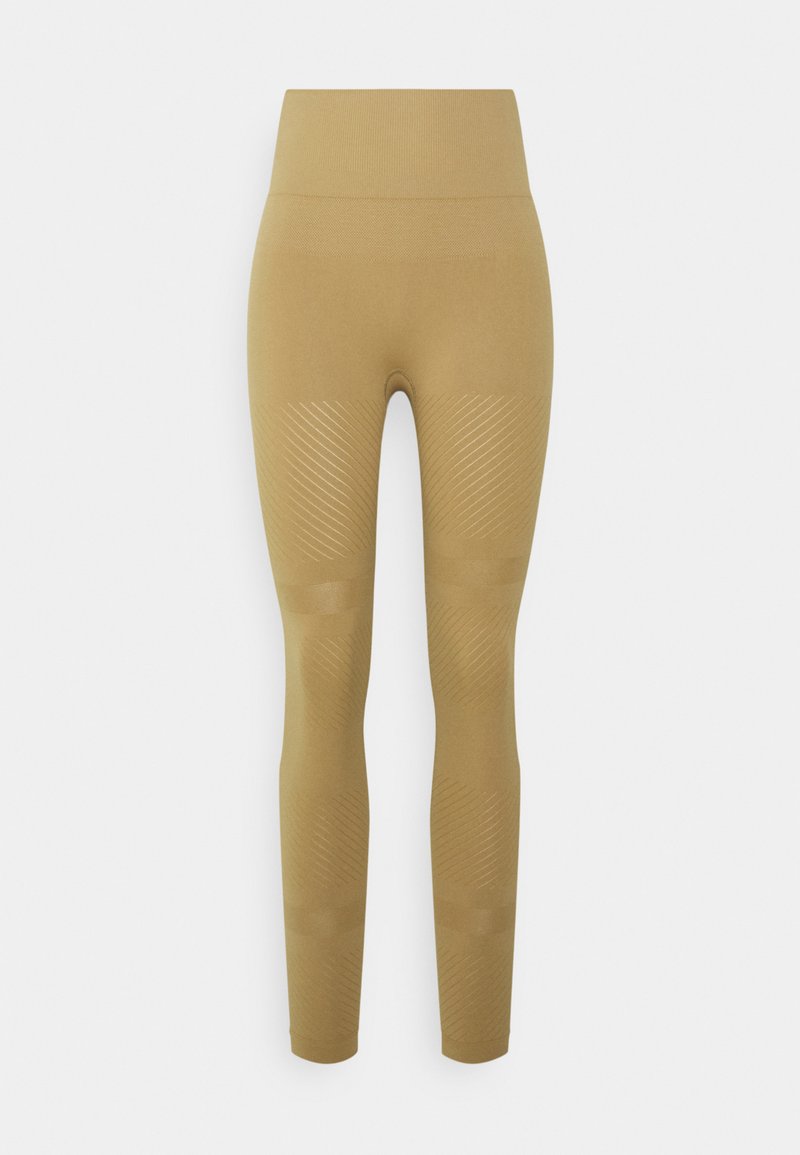 Leggings bege com cintura alta, textura canelada e padrão de riscas diagonais nas pernas inferiores. Feitas de um tecido liso e elástico.