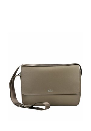 Brązowa torba listonoszka z regulowanym paskiem na ramię i małym metalowym logo krokodyla na przedniej klapie.