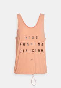Top in pesca con scollatura a girocollo e orlo regolabile con coulisse; presenta un bold testo nero: "NIKE RUNNING DIVISION." Texture liscia.