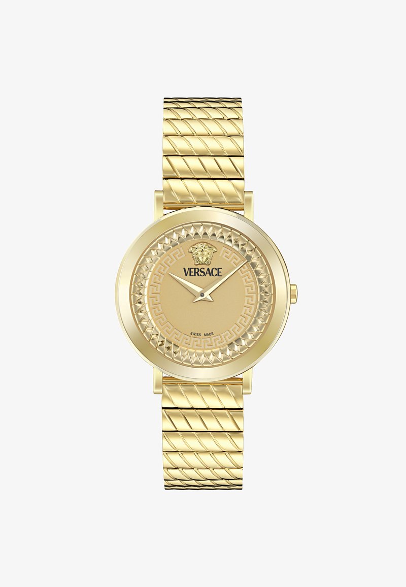Orologio d'oro con cinturino testurizzato e quadrante rotondo. Le caratteristiche includono un motivo a chiave greca e un emblem di leone, con la dicitura "Swiss made" sul quadrante.