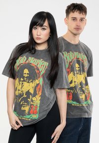 Gray cotton t-shirts with a vintage Bob Marley graphic in yellow, green, and red. Loose fit, short sleeves, and crew neck design.