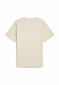 Cremefarvet bomulds t-shirt med korte ærmer. Bagsiden har "Turbo Club" i hvid skrift, ledsaget af grafiske elementer.
