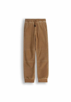 Brązowe dresowe spodnie z weluru z elastycznym pasem, sznurkiem, bocznymi kieszeniami, szwami na kolanach i prążkowanymi mankietami na kostkach na białym tle.