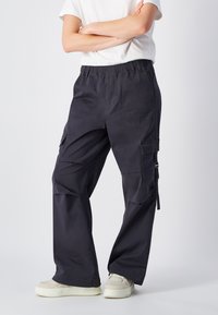 Donkergrijze cargobroeken met een elastische tailleband, zijzakken en een relaxte pasvorm. De stof is glad en duurzaam, geschikt voor casual gebruik.
