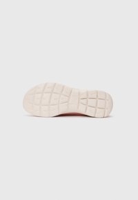 Sole of a light pink athletic shoe with a textured, grid-patterned rubber outsole on a white background.