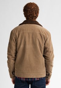 Giacca in velluto a coste marrone con un colletto in shearling spesso di colore marrone scuro. Caratteristiche includono una texture robusta e una vestibilità casual. Bottoni sui polsini.