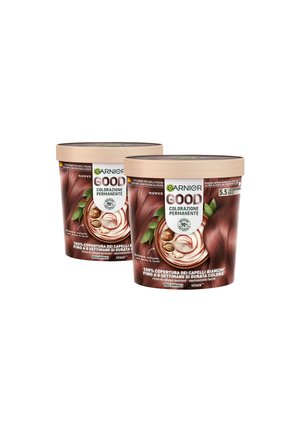 Due contenitori rotondi di colorazione permanente per capelli Garnier Good, marroni con una superficie testurizzata, dotati di un coperchio beige e etichette colorate in diverse lingue.