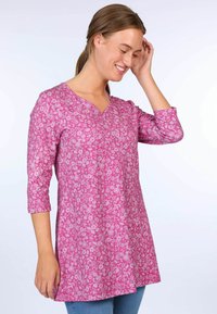 Pink floral tunic top with three-quarter sleeves and a V-neck design. Features a soft texture and is knee-length with a flared silhouette.