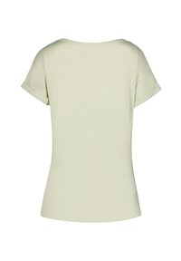 Blusa de manga corta verde claro con escote redondo y puños enrollados. Textura suave con un ligero brillo, silueta ajustada.