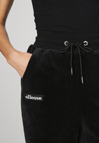 Ellesse INDIA PANT - Tepláky - black