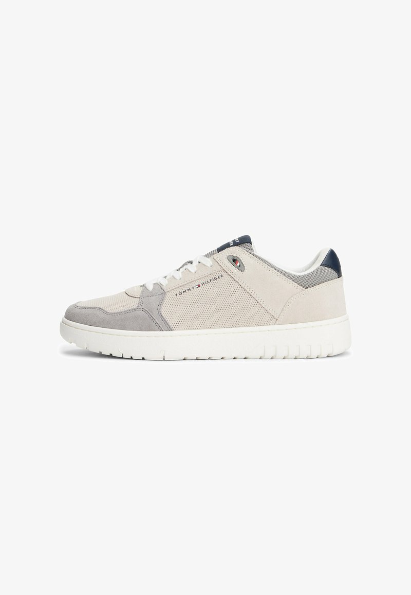Zapatilla gris claro hecha de malla y ante con una suela de goma blanca. Presenta un detalle en navy en el talón y el logo en el costado.
