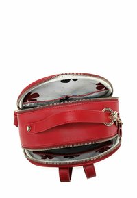Červená kožená kabelka s dvojitými přihrádkami na zip, květovanou látkovou podšívkou, popruhem na rukojeť a zlatými kroužky na klíče a přívěsky.