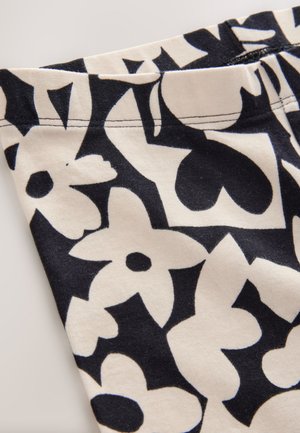 Baumwollstoff mit einem marineblauen und cremefarbenen Blumenmuster, das kräftige Formen und Umrisse zeigt. Glatte Textur mit sauberer Naht am Rand.