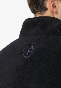 Czarna polarowa kurtka z wysokim kołnierzem, z purpurowym haftowanym logo. Miękka tekstura z dopasowanym krojem w okolicy szyi.