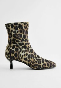 Kožené kotníkové boty s leopardím vzorem, špičatou špičkou, černým podpatkem, elastickým textilním svrškem a hladkou texturou. Vyznačují se bezespárovým designem a minimalistickou siluetou.