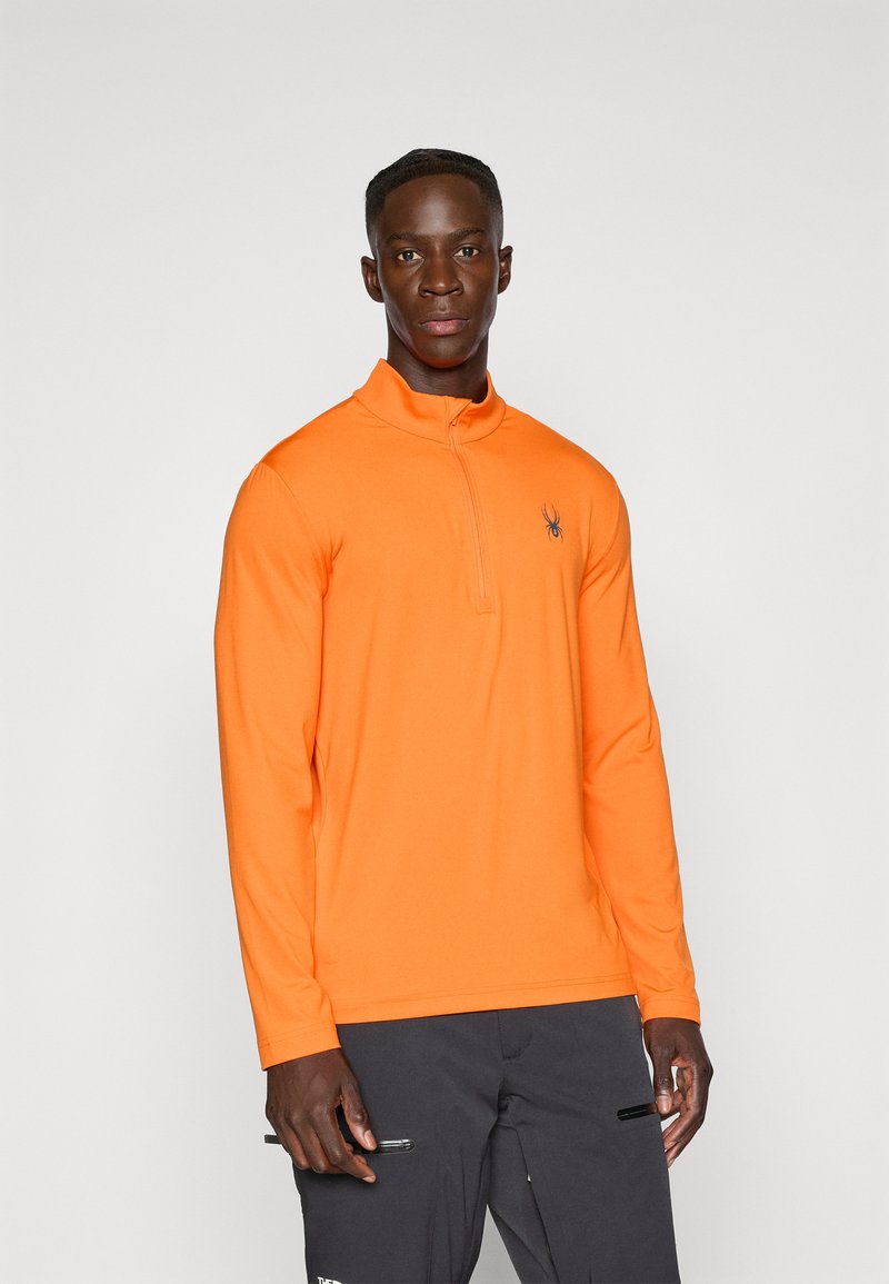 Oranges Langarm-Zip-Kragen-Oberteil aus leichtem Material, mit einem dunklen Spider-Logo auf der Brust und einer glatten Textur.