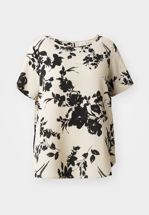 Blouse à manches courtes à motif floral en crème avec des fleurs noires. Encolure ronde, coupe ample, tissu texturé, fentes latérales au bas.