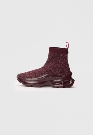 Burgundia värvi sokist inspireeritud sneaker, millel on tekstureeritud kudum, integreeritud tõmbepealne ja paks, skulptuuriline kummitald.