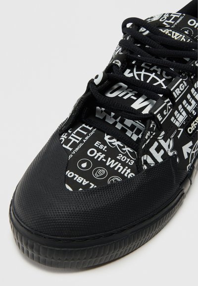 Mustad tennis, millel on tekstuuriga kummist talla ja pealmise osa, valge Off-White brändingu ja erinevate graafiliste printidega. Paeltega disain, ümar nina.