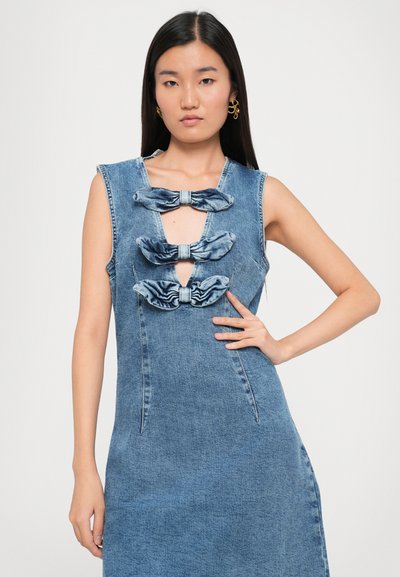 Denimmekko, jossa on vartalonmyötäinen malli, hihaton muotoilu ja kolme kangaspäällysteistä nauhaa rinnassa. Vaaleansininen väri, jossa on teksturoitu pinta.