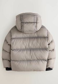 Puffjacka i ljusgrått, med avtagbar huva, quiltat mönster, elastiska ärmmuddar och en logotyp på nederkanten. Mjuk och slät textur.