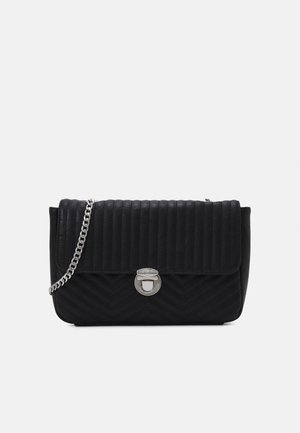 Sort quiltet crossbody taske med sølvkæde strop og sølv drejelås lås på frontklappen.