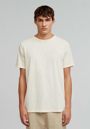 Cremfarbendes, kurzärmeliges T-Shirt mit Rundhalsausschnitt, aus strukturiertem Stoff gefertigt, mit einem lockeren Schnitt und minimalistischem Design.
