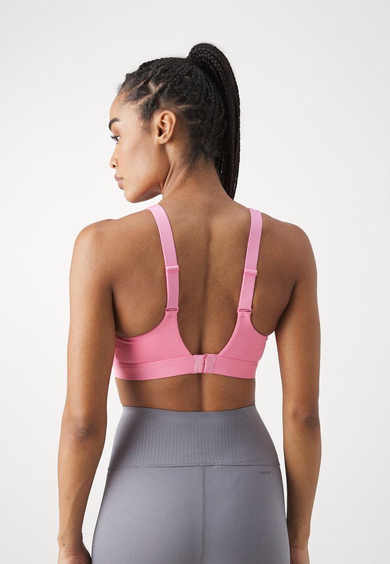 Rosa Sport-BH mit verstellbaren Trägern, aus glattem Material. Verfügt über einen Hakenverschluss und ein Racerback-Design für zusätzlichen Halt.