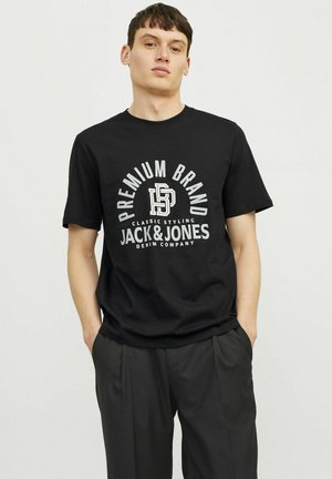Sort bomulds T-shirt med hvidt trykt tekst med "Premium Brand" og "Jack & Jones Denim Company." Kortærmet, rund hals design.