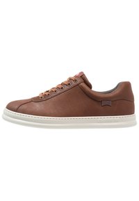 Zapatilla de cuero marrón con un diseño de corte bajo, que presenta cordones beige y detalles de costura lateral. Suela de goma blanca con acentos de logotipo.