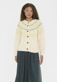 Cardigan tricotat de culoare crem, cu guler rotund, având modele de culoare verde deschis și gri, butoane maronii mari și manșete și tiv cu nervuri.